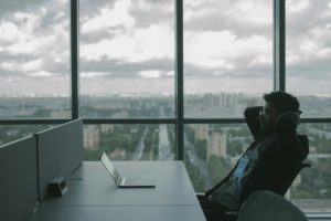 A person sits at a desk in front of a laptop, accessing HR Cloud