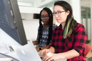 A professional woman working on a PC, managing payroll automation processes