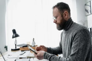 A man analyzing a Fragmented Global payroll on his desk in a well-lit office