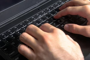 Person typing on a laptop using a modern payroll solution