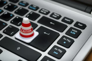 Caution symbol on keyboard representing secure Swiss payroll data protection