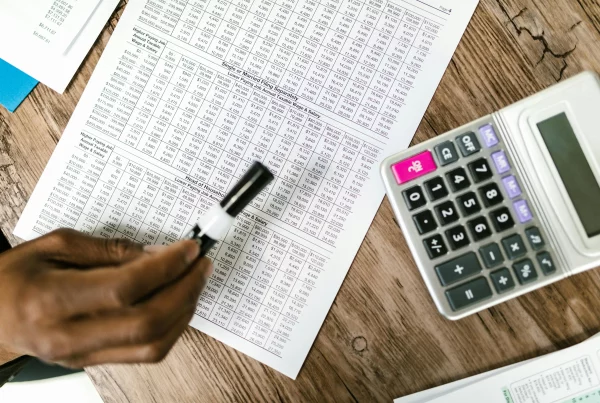 Calculator and organized tax forms symbolizing efficient payroll processing