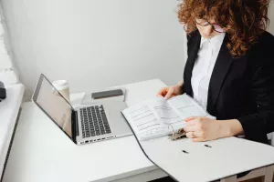 Payroll company specialist analyzing payroll document on laptop