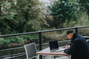 Man working on a laptop from a flexible location of his choice, representing remote employees in a comfortable and adaptable workspace.