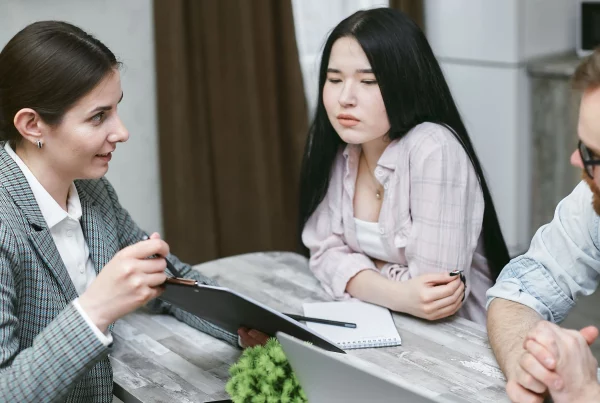 HR professional explaining mandatory employee benefits and insurance requirements in Switzerland to employees during a workplace meeting, highlighting social security, pension contributions, accident insurance, and employer-employee responsibilities.