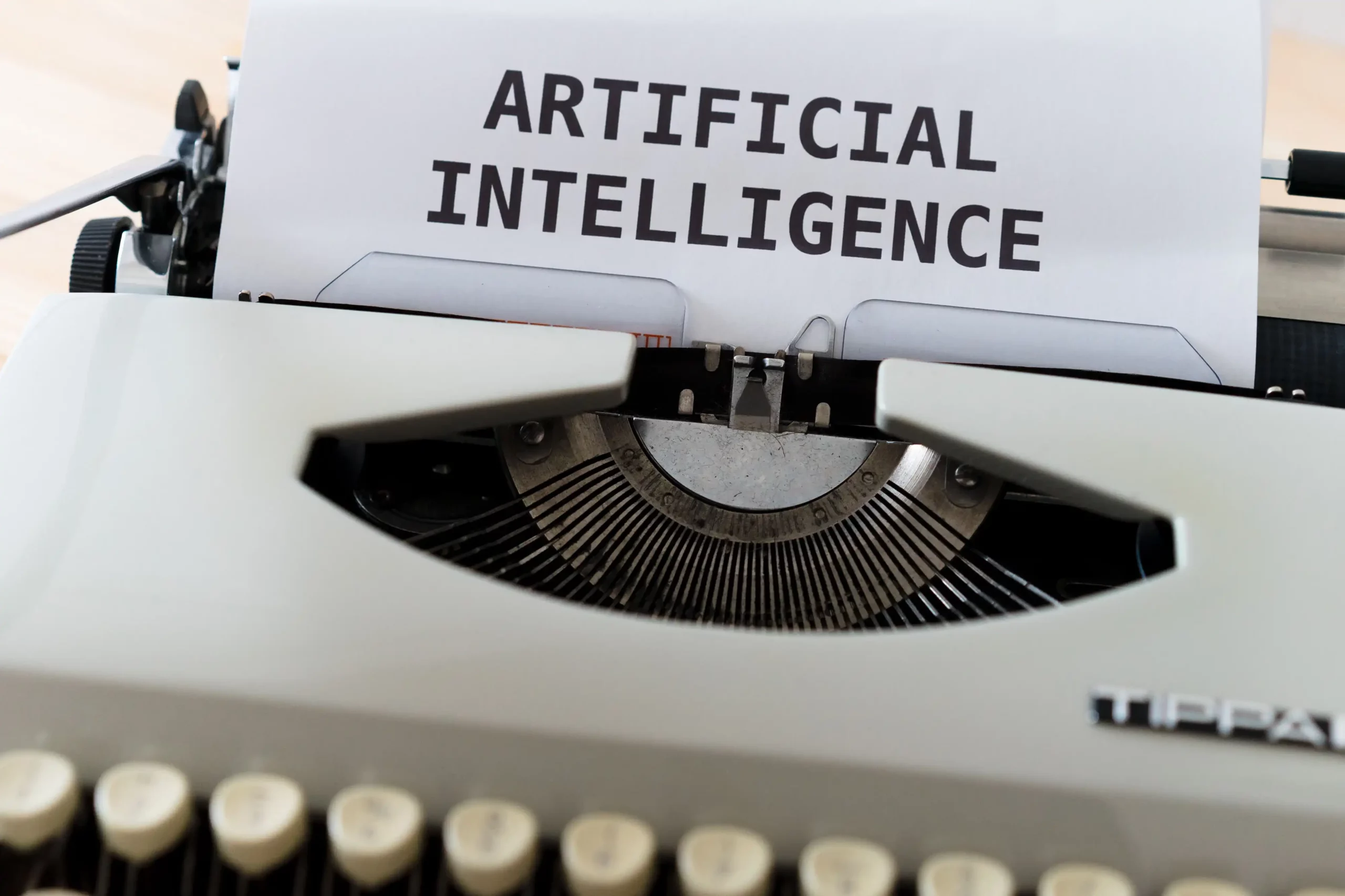 Typewriter displaying the words “Artificial Intelligence,” representing the impact of AI on payroll jobs and automation.